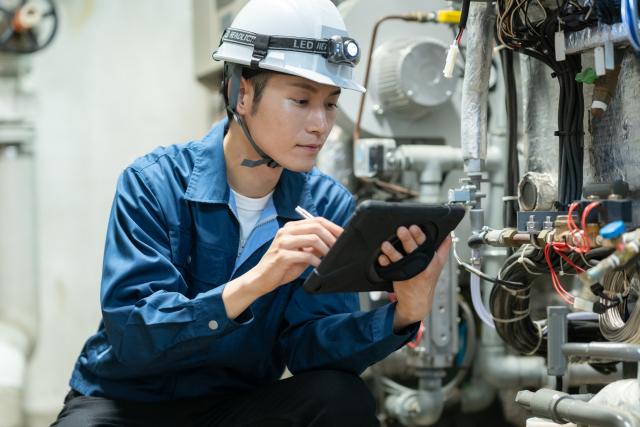 タブレットで設備の状態を確認する作業者