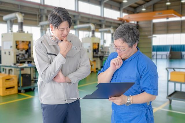 工場で打ち合わせをする作業者
